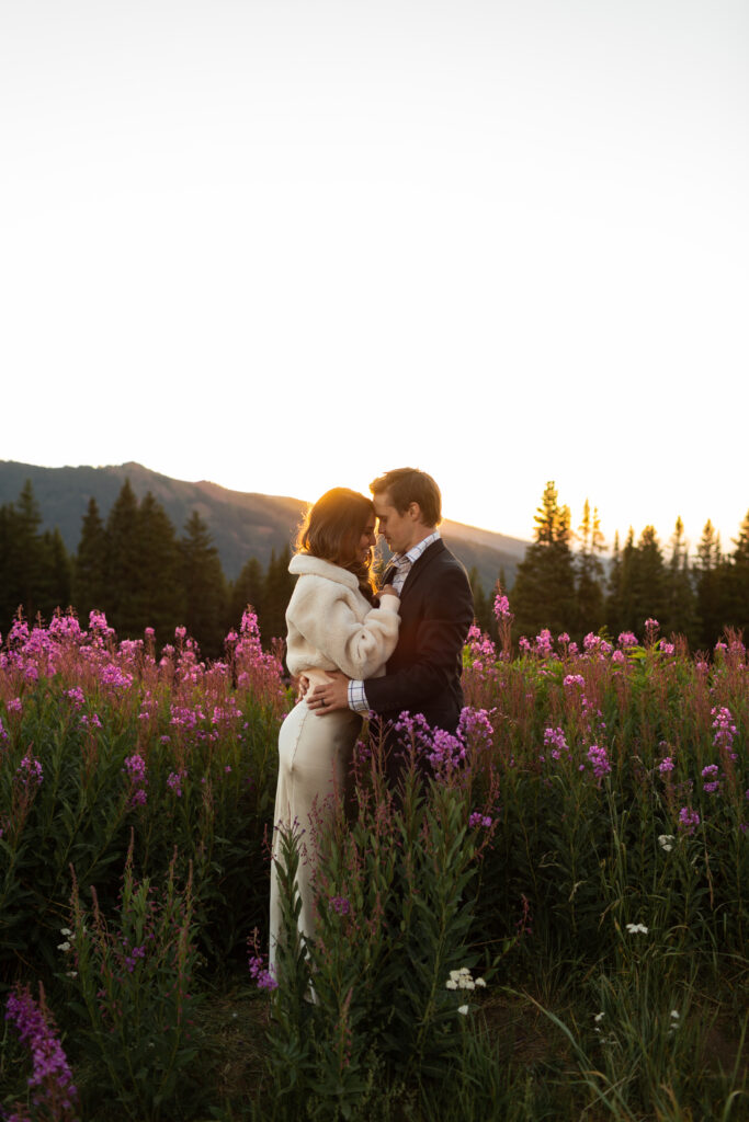 colorado elopement photographer taking photo of bride and groom in wildflowers