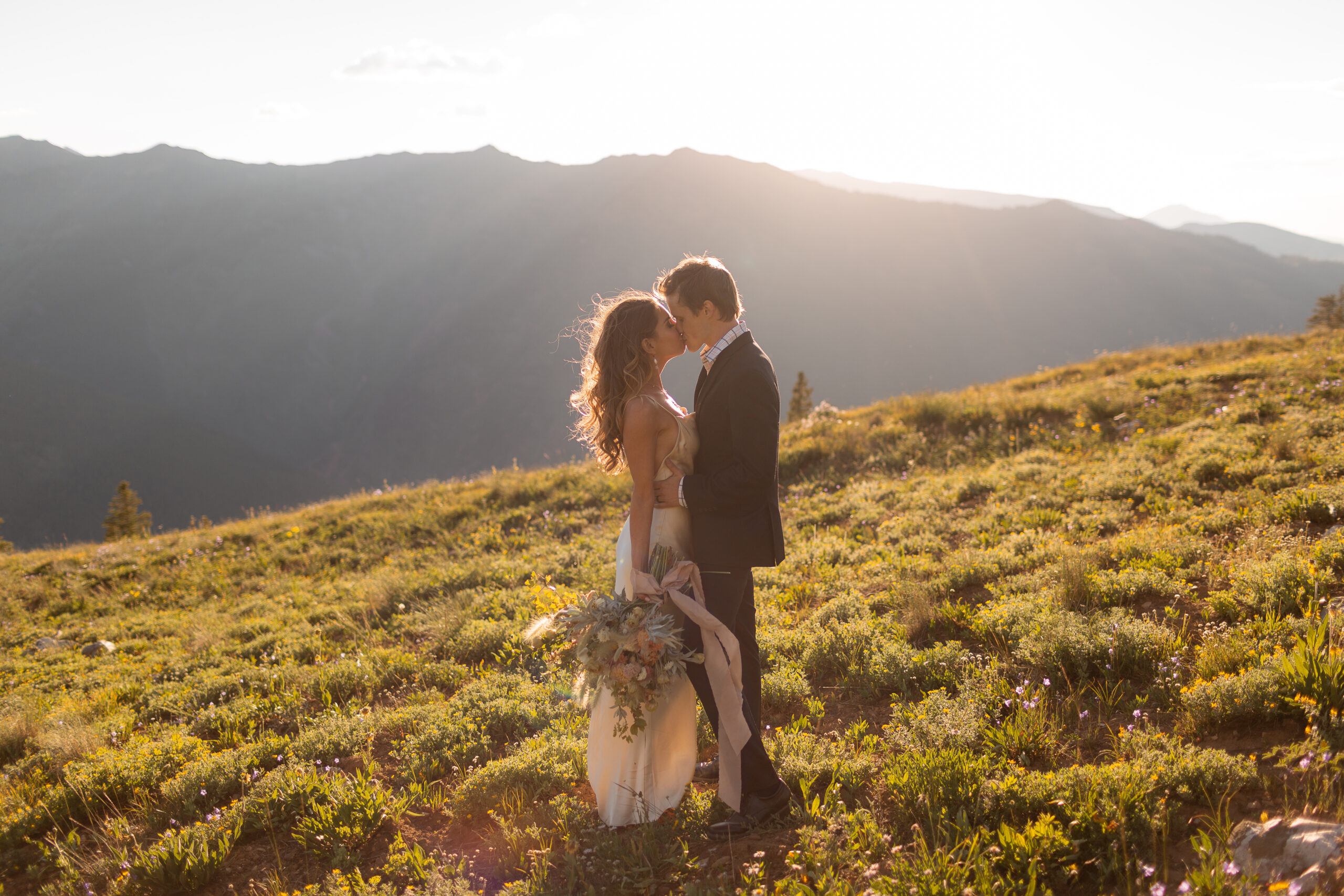 aspen elopement celebration with bride and groom kissing on the mountain