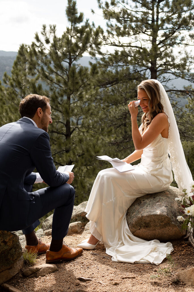 bride wiping tears during vow reading at wedding in boulder