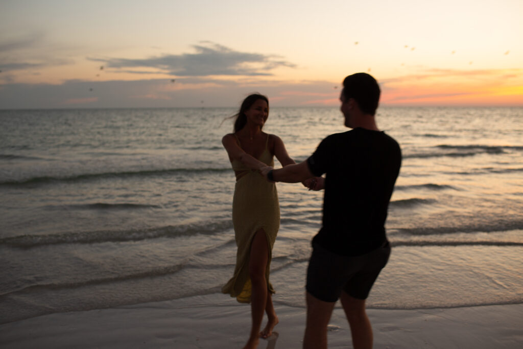 couple dancing in the ocean waves at sunset on anna maria island