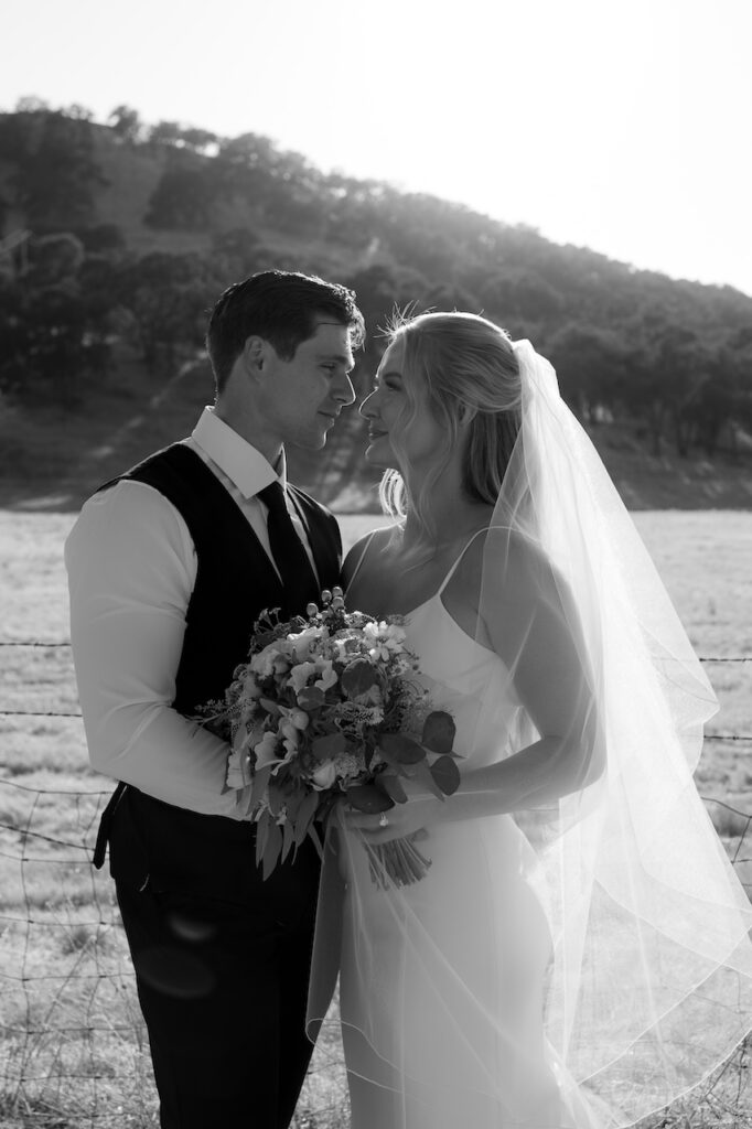 Bride and groom sharing a kiss at sunset during California backyard wedding