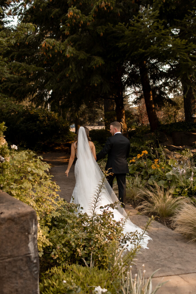 bride and groom walk through beautiful trees in oregon