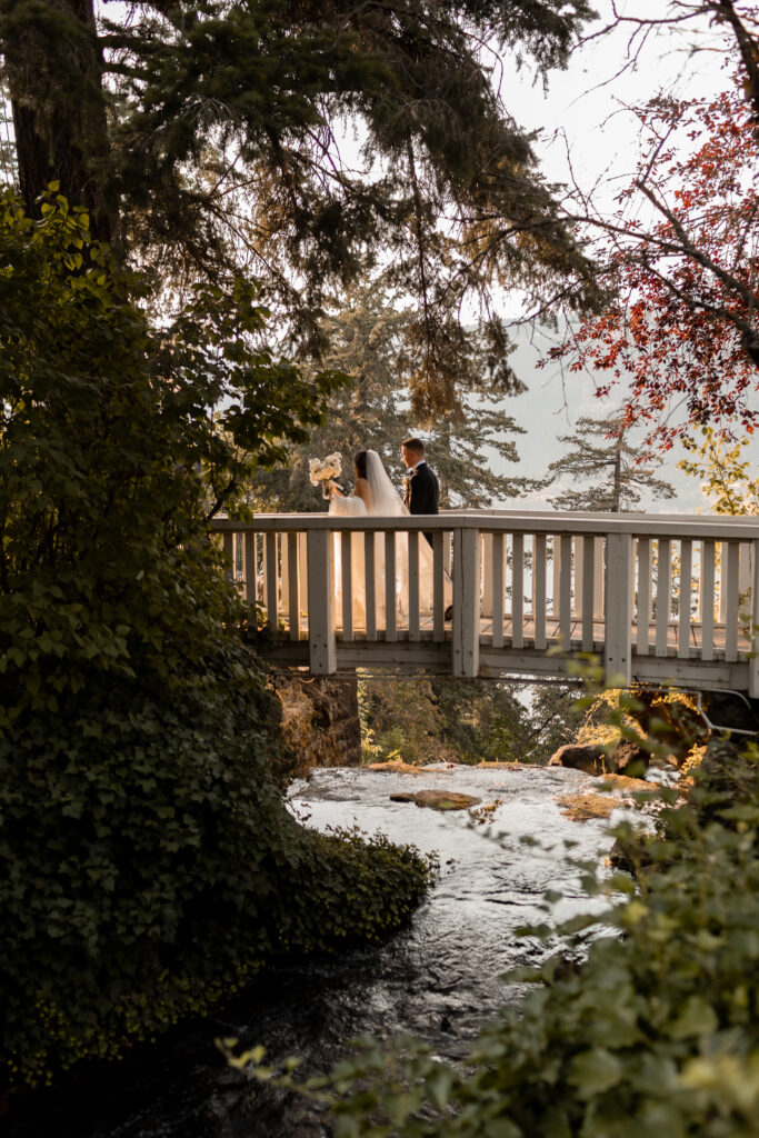 bride and groom cross bridge at columbia gorge hotel & spa