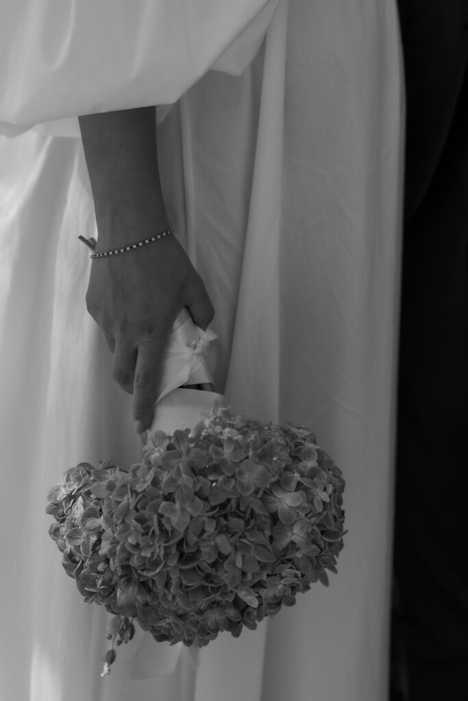 Close-up of bride’s hand holding a hydrangea bouquet at a luxury California estate wedding.