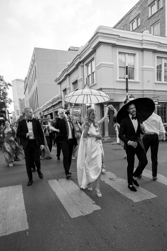 The new bride and groom dance through the streets of New Orleans. Vintage umbrellas are used as a decorative statement for the newly weds!