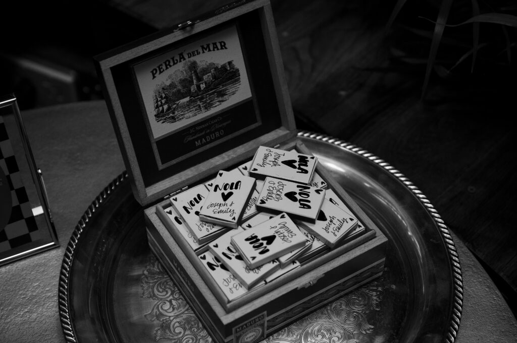 Party favors of NOLA stamped match boxes are placed in an antique cigar box.