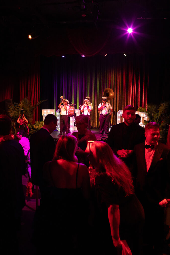 The second line band comes up onto the stage of the reception to share more music while people dance and drink.