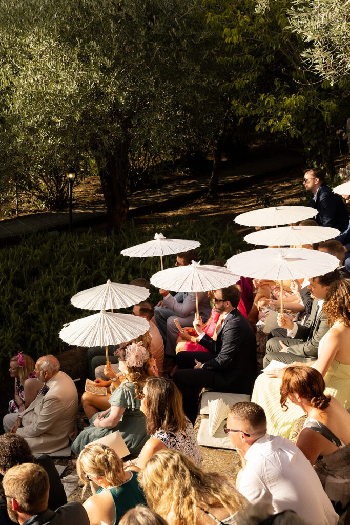 guests holding parasols at the italy wedding ceremony