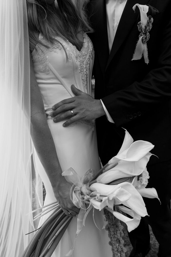 details of the bride and groom dress, suit, and bouquet