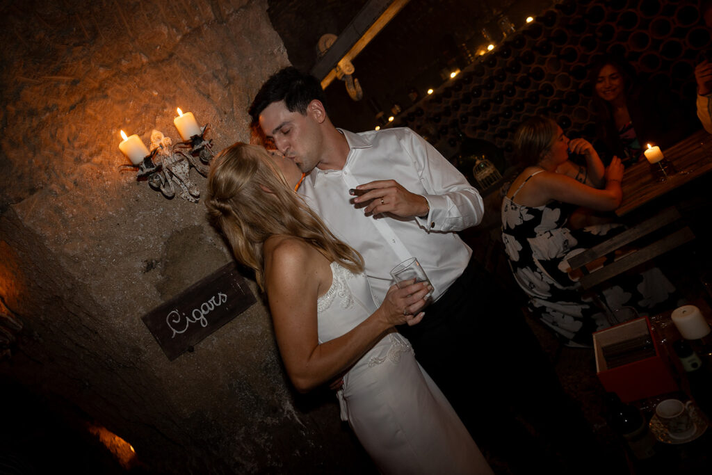 bride and groom kiss in the cigar bar late night after wedding