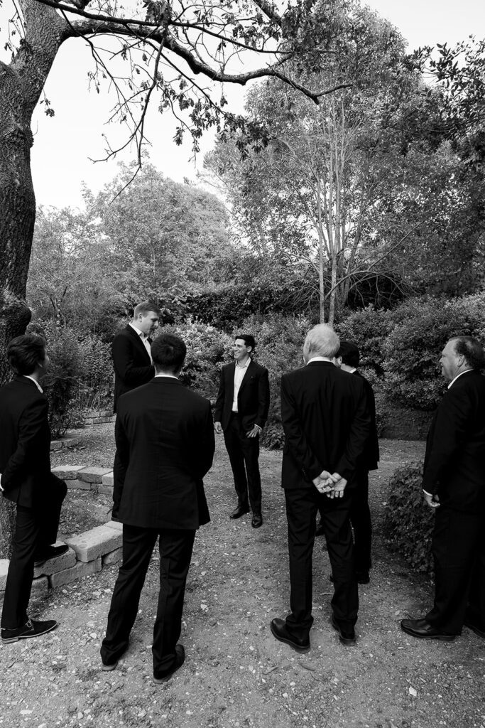 groom and groomsmen standing in the gardens before first look