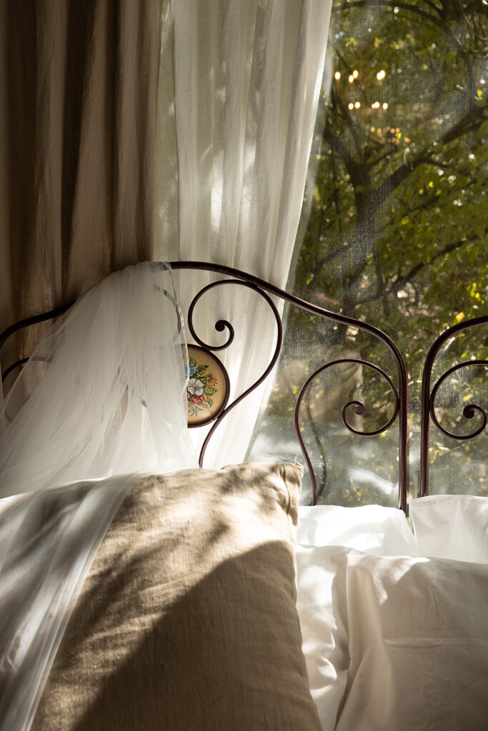 veil hanging on the bed detail with sunlight coming through the window