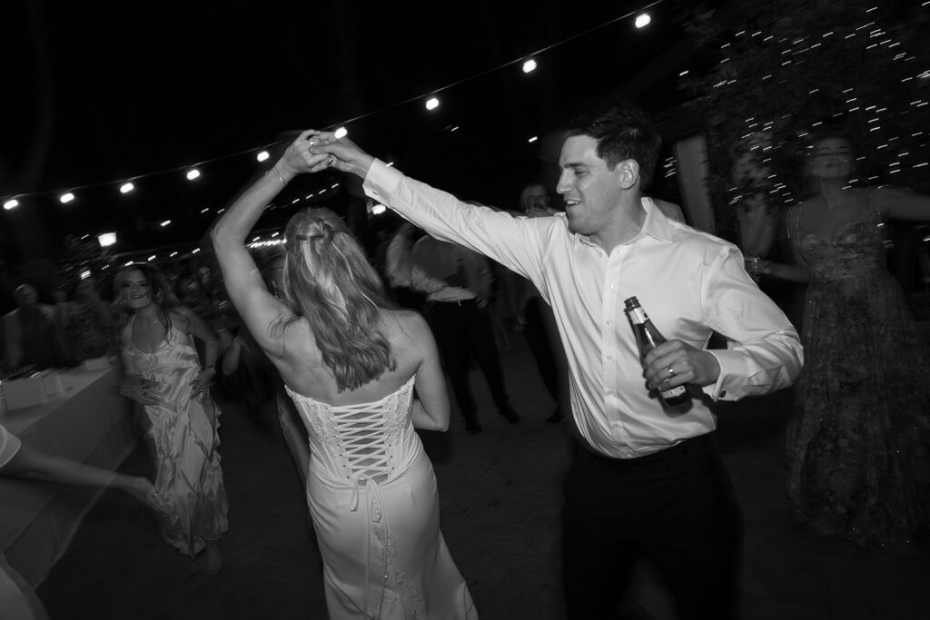 groom sping his bride dancing at their le 7 fonti wedding reception